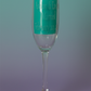 Stemmed champagne flute with teal backing and Kustom Kreationz branding
